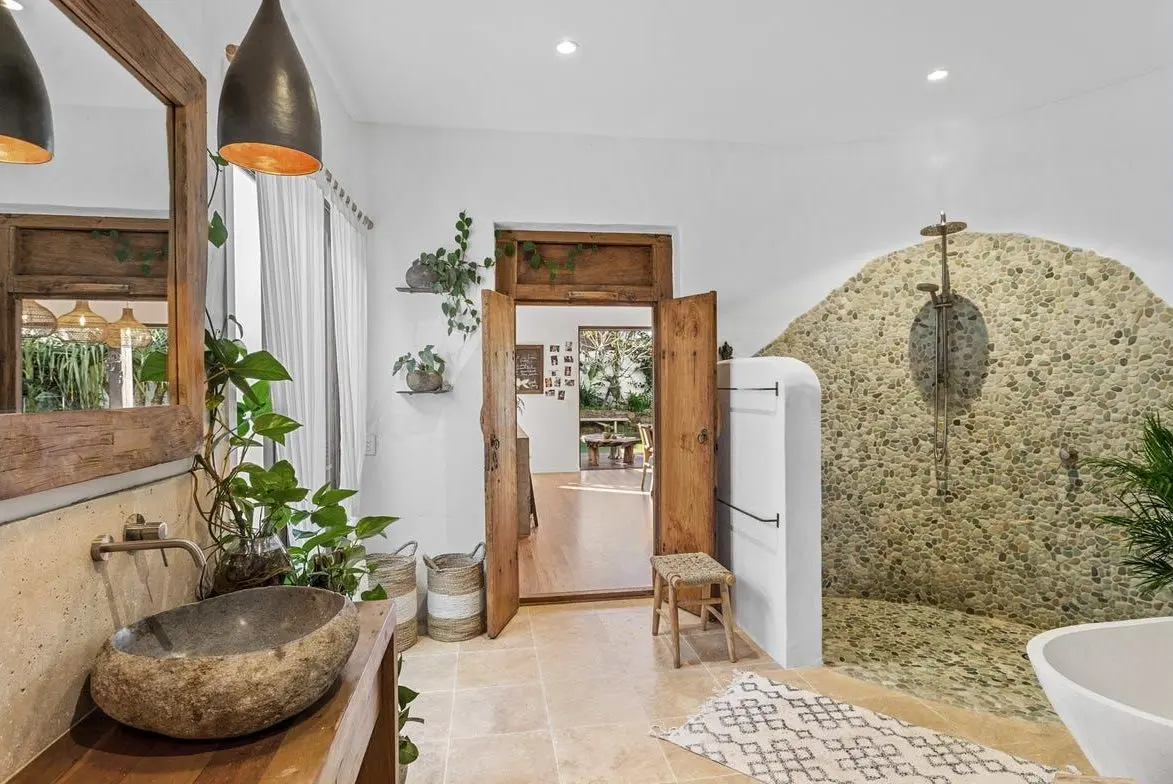 Ensuite with a stone basin and pebble-tiled shower