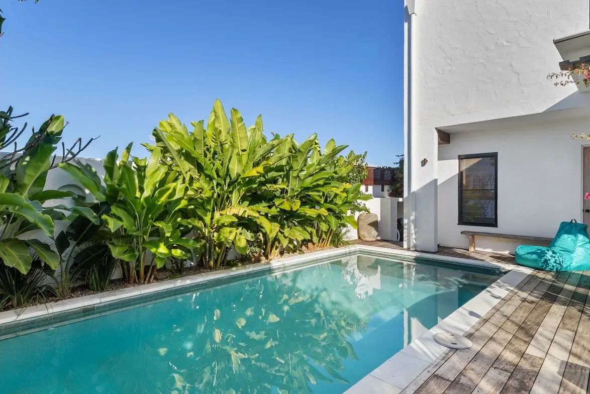 Pool edged with tropical planting and a timber deck